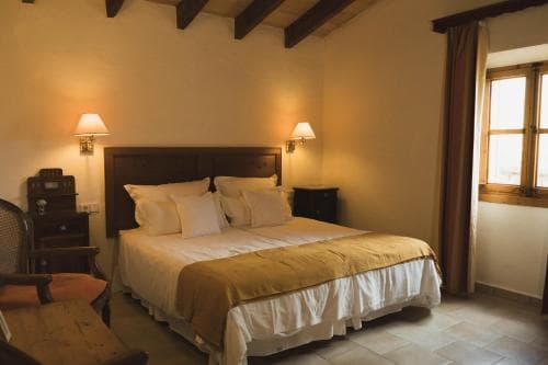 Bedroom in Finca Can Estades with double bed, wooden furniture, and window light.