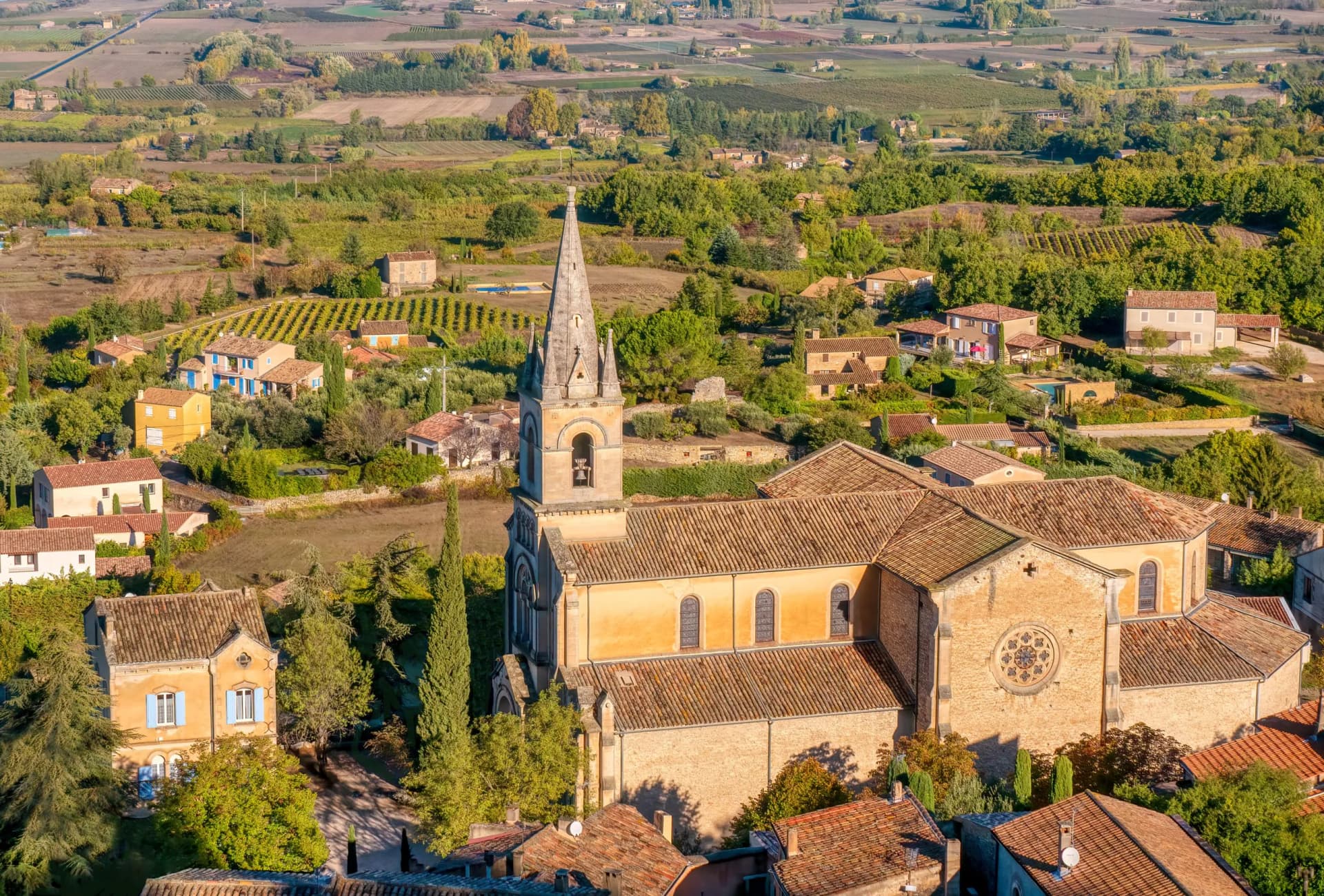 High-angle view of Eglise Bas church in Bonnieux village, Luberon, Provence, France, surrounded by greenery.