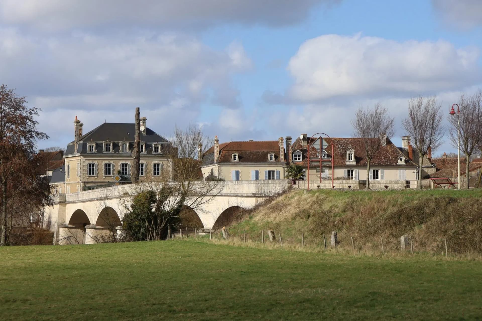 Stone arch bridge over river near houses in Saint-Savin-sur-Gartempe, Vienne, France.