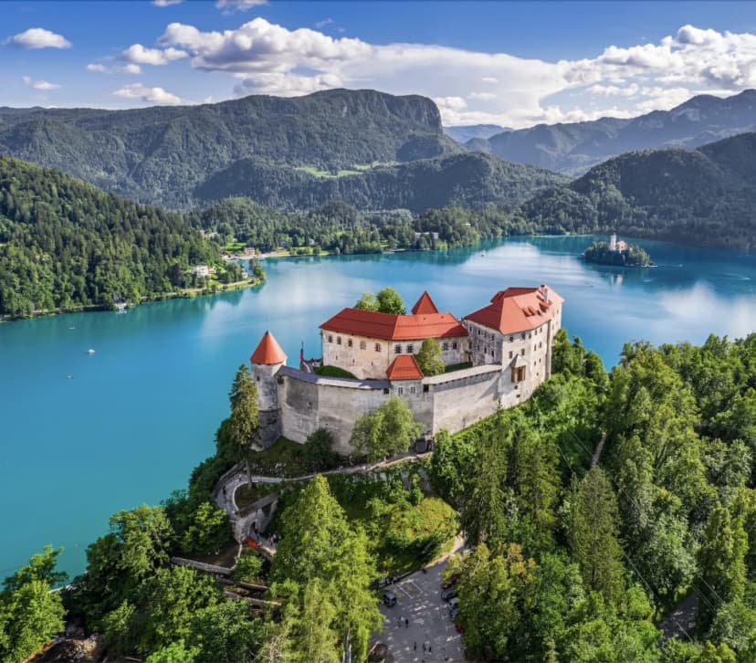 Bled Castle overlooking turquoise Lake Bled with island church and Julian Alps, Slovenia