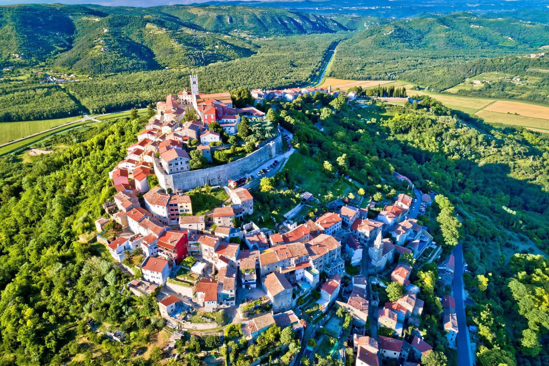 Hilltop medieval town of Motovun, Croatia, surrounded by lush green forests and valleys.