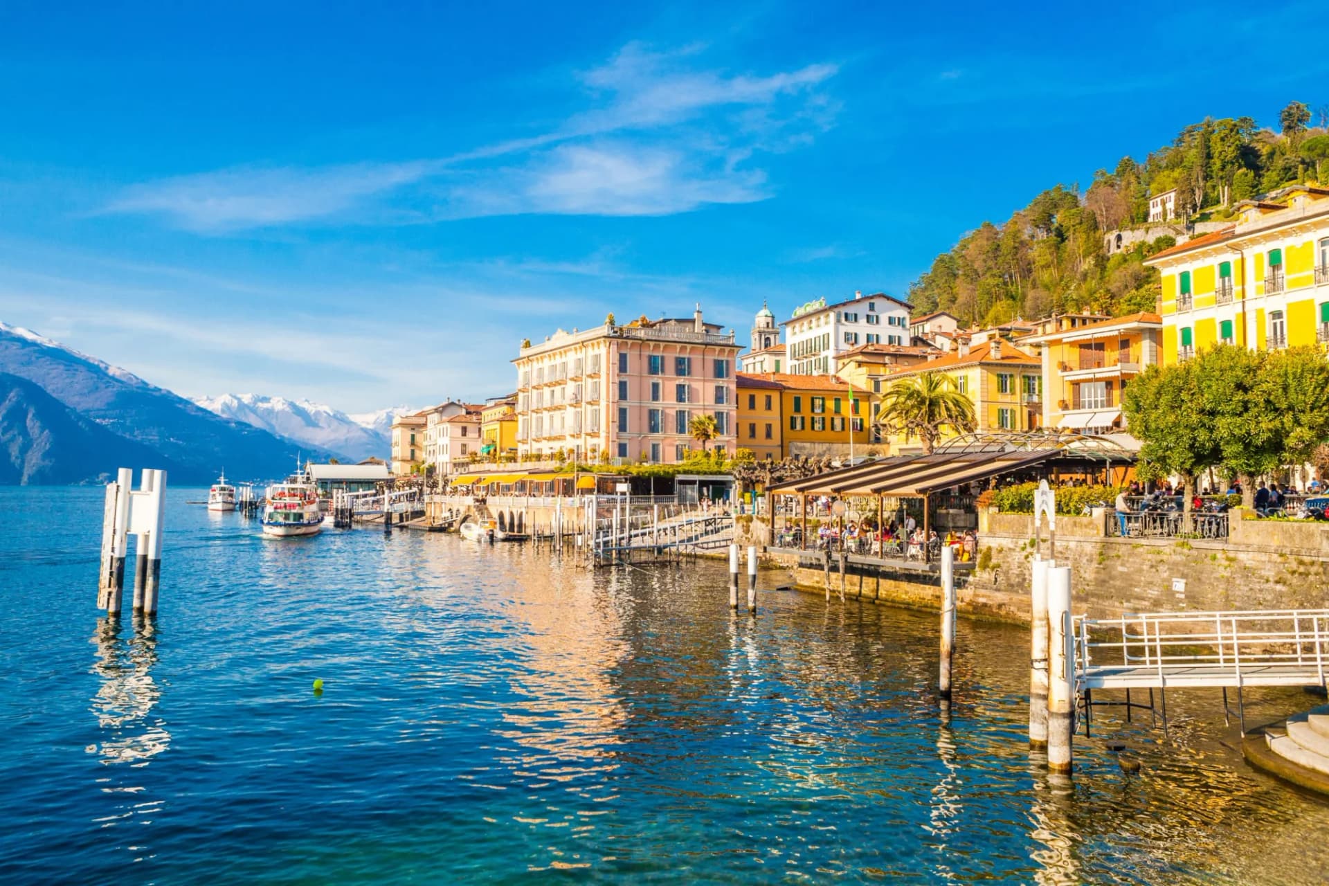 Bellagio resort town on Lake Como with colorful buildings, boats, and snow-capped mountains.