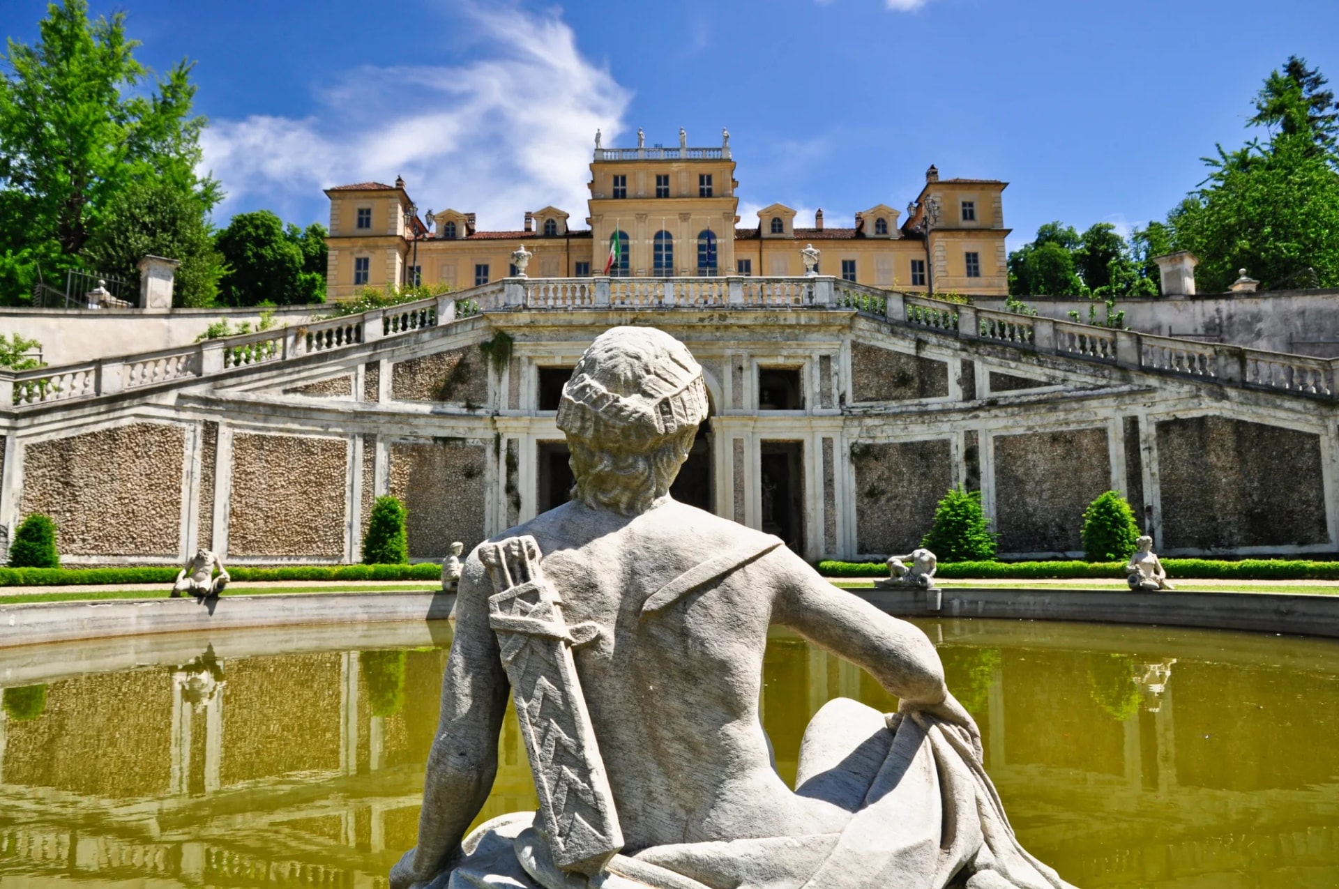 Stone statue overlooking pool toward Villa della Regina in Torino, Italy.