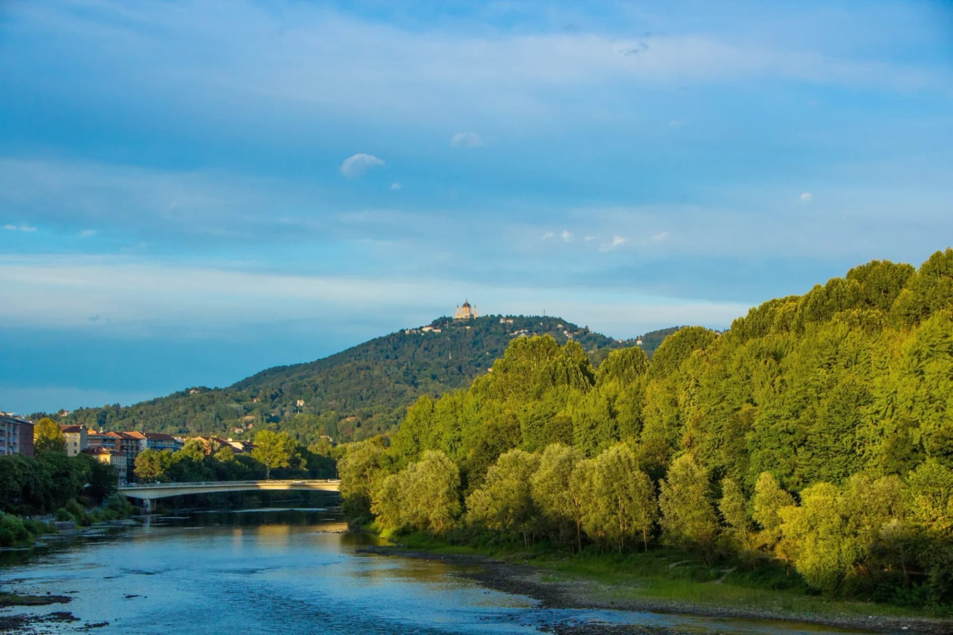 River Po panorama with Basilica of Superga on a green hill above Turin.