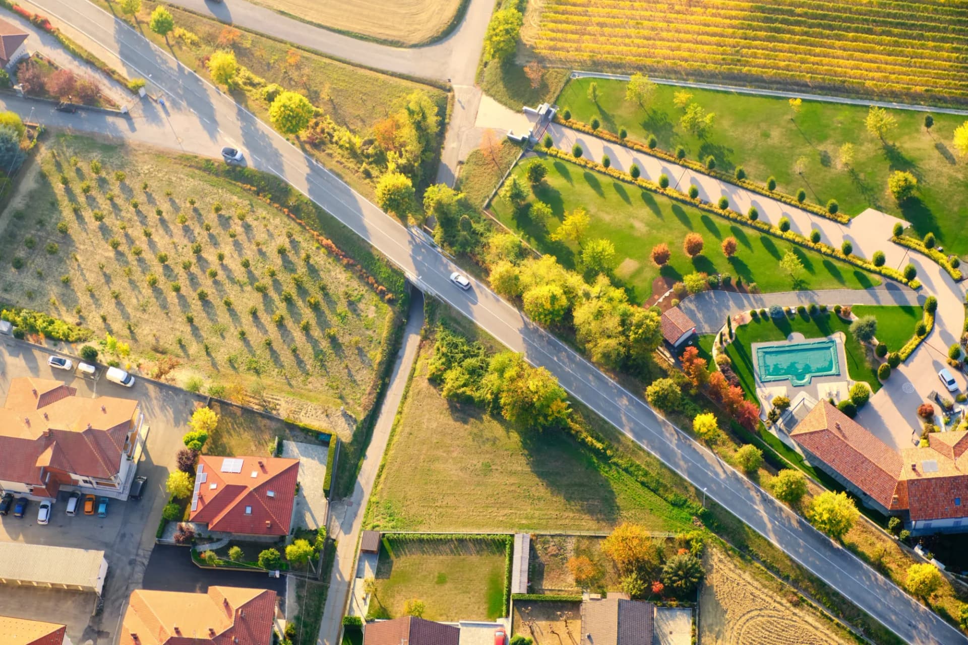 Aerial view of villages, vineyards, and houses in the hilly Langhe Roero region of Piedmont, Italy, during fall.
