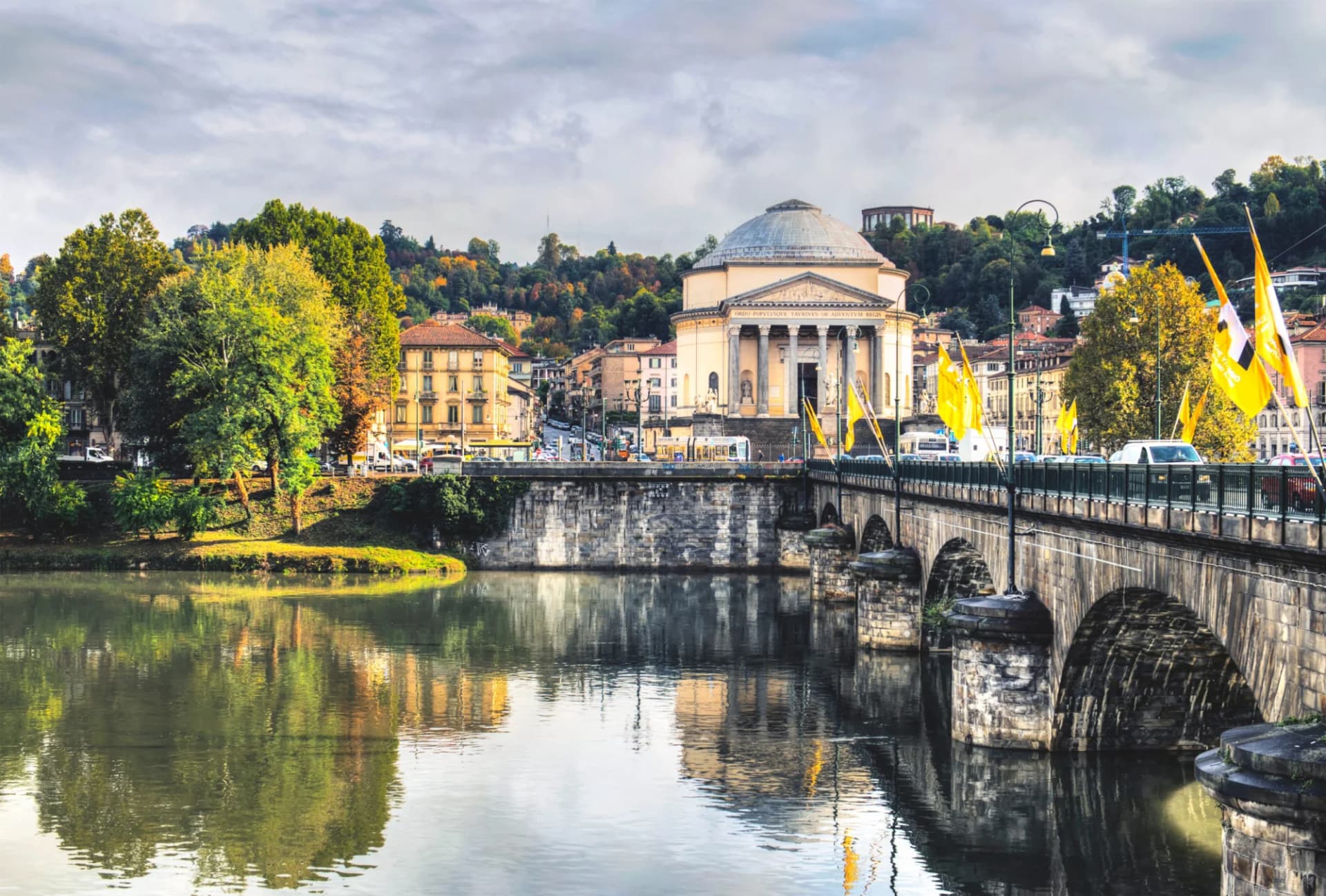 Ancient stone bridge over the River Po in Turin with the dome of the Gran Madre di Dio church.