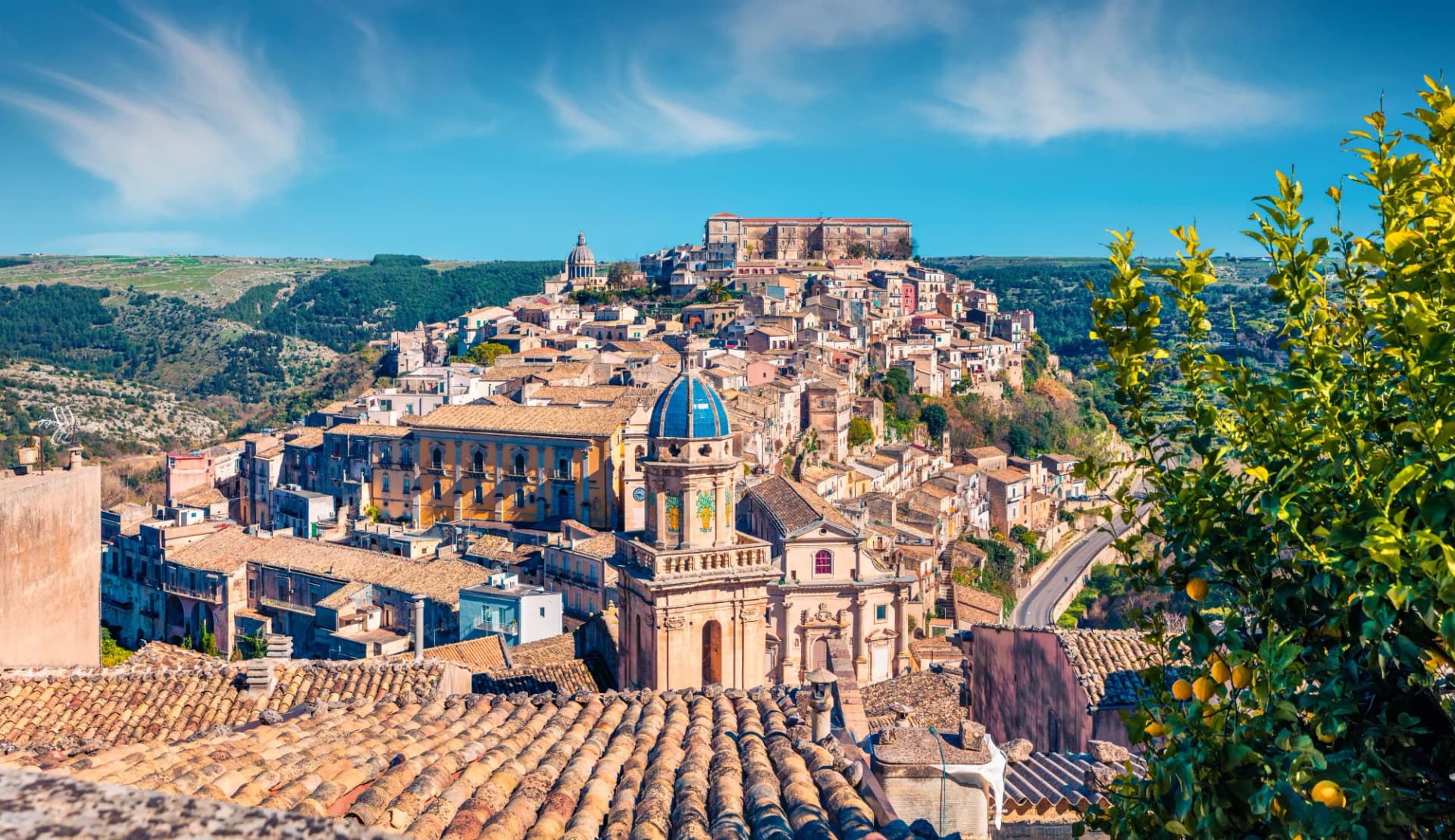Sunny Ragusa cityscape with Palazzo Cosentini and Duomo di San Giorgio church dome.