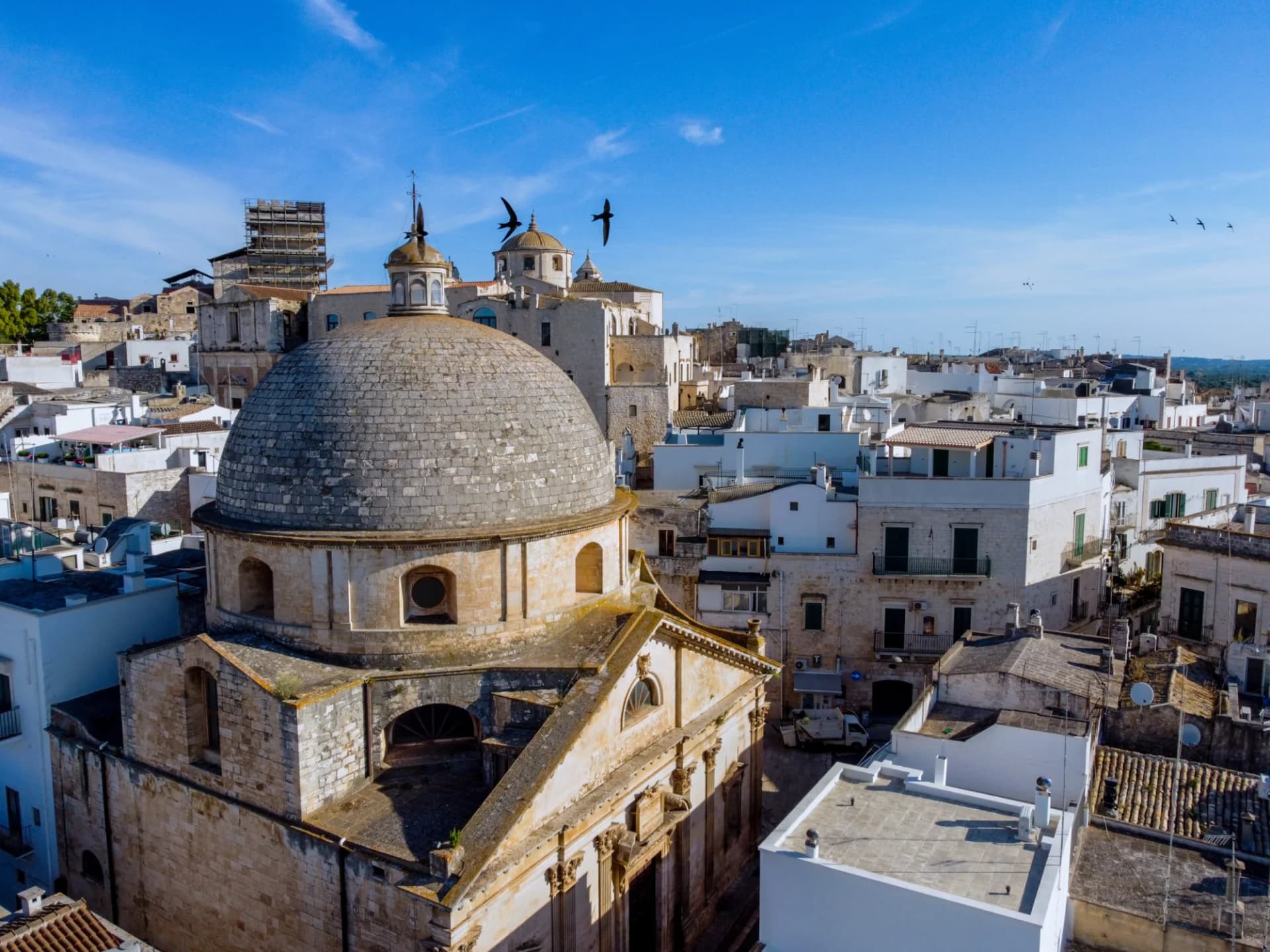Aerial view of San Gioacchino church dome over white buildings in Ceglie Messapica, Southern Italy.