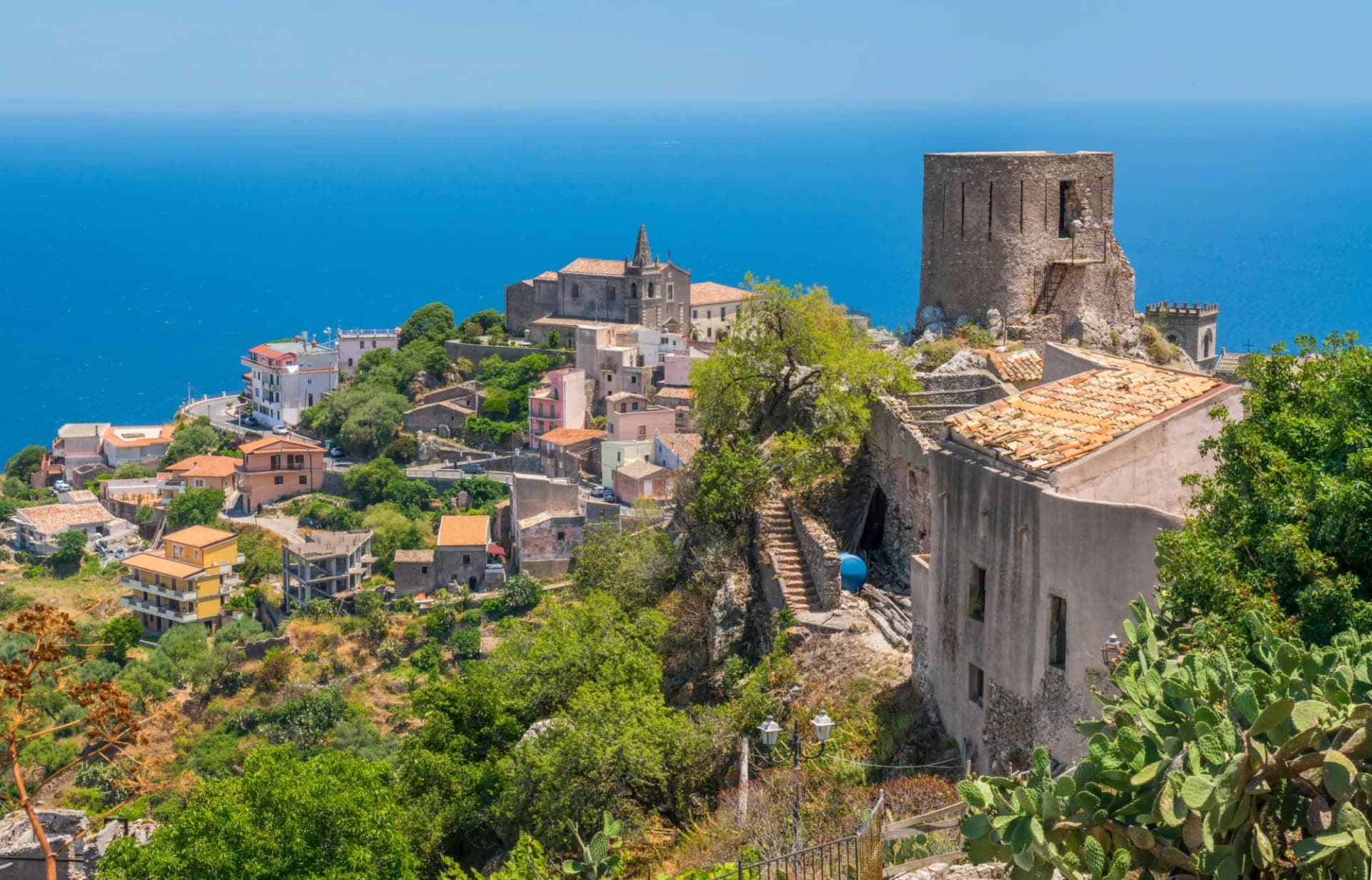 Picturesque town in Messina, Sicily, built on a hillside above the deep blue sea.