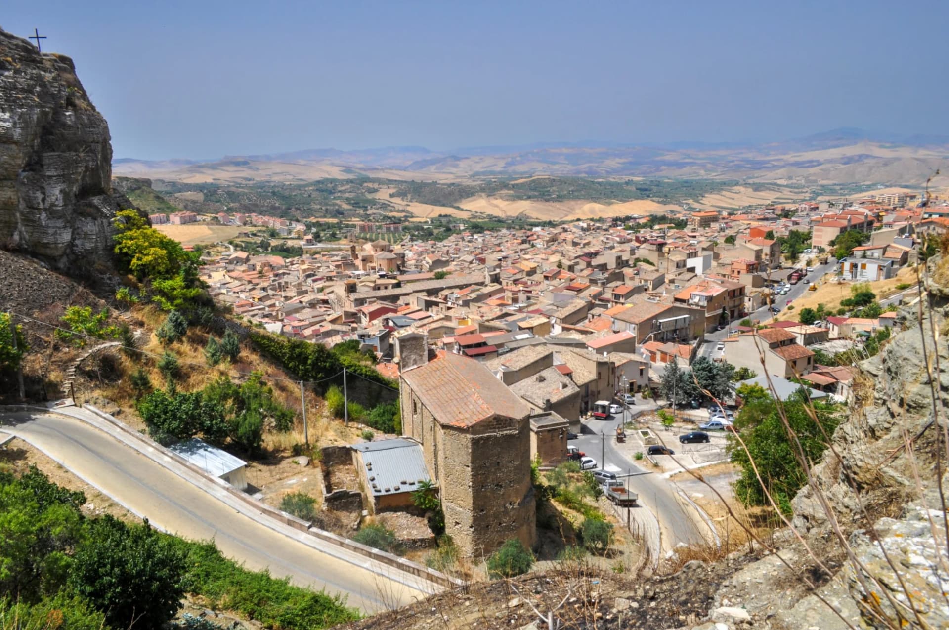 View from above Corleone village with dense terracotta roofs and dry, hilly landscape.