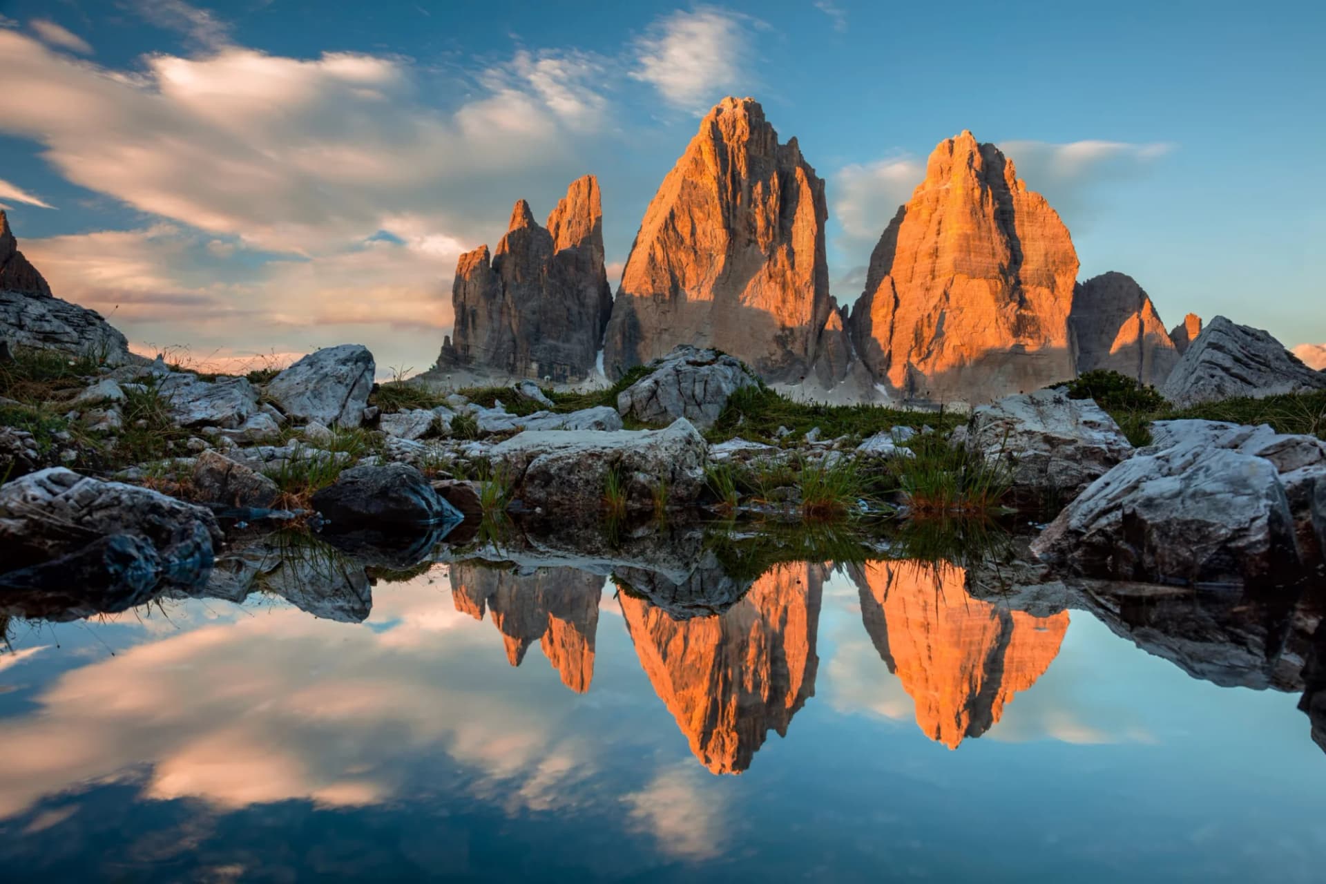 Tre Cime di Lavaredo mountains reflected in a still alpine lake at sundown, Dolomites.