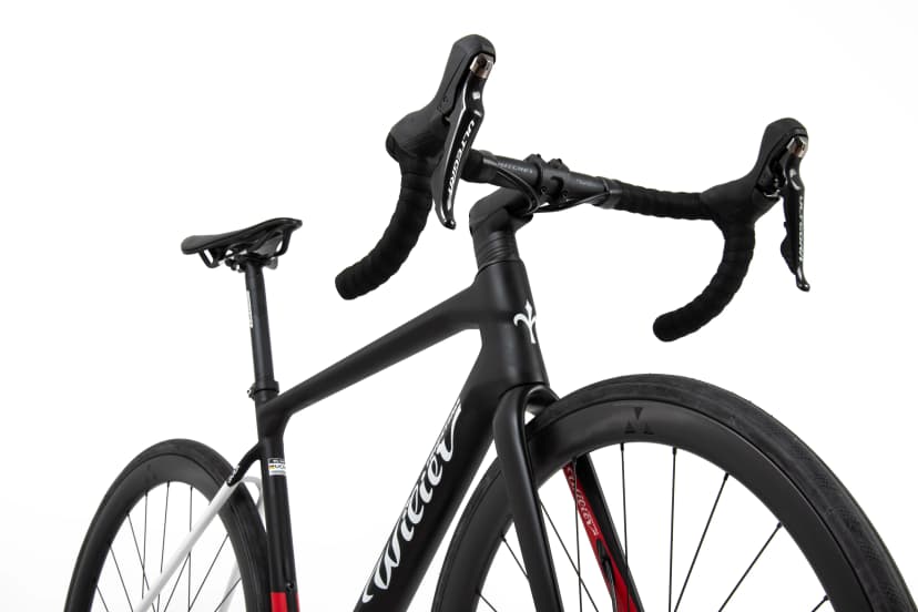 Close-up of black Wilier GTR road bicycle frame, handlebars, and wheels on white background.