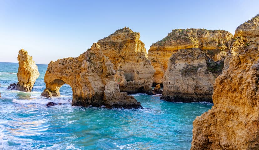 Panoramic view, Ponta da Piedade near Lagos in Algarve, Portugal. Cliff rocks and tourist boat on sea at Ponta da Piedade, Algarve region, Portugal. Ponta da Piedade, Algarve region, Portugal.