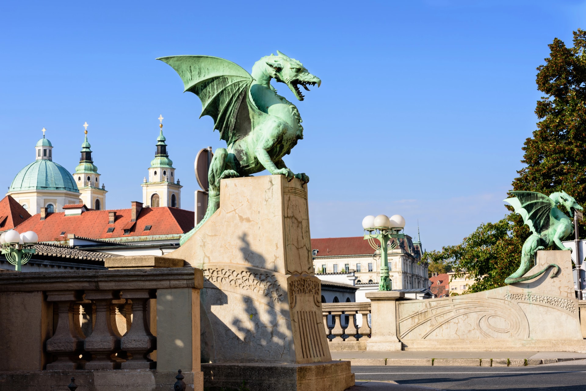 Dragon Bridge with view of Cathedral Saint Nicholas on blue sky, Ljubljana Slovenia