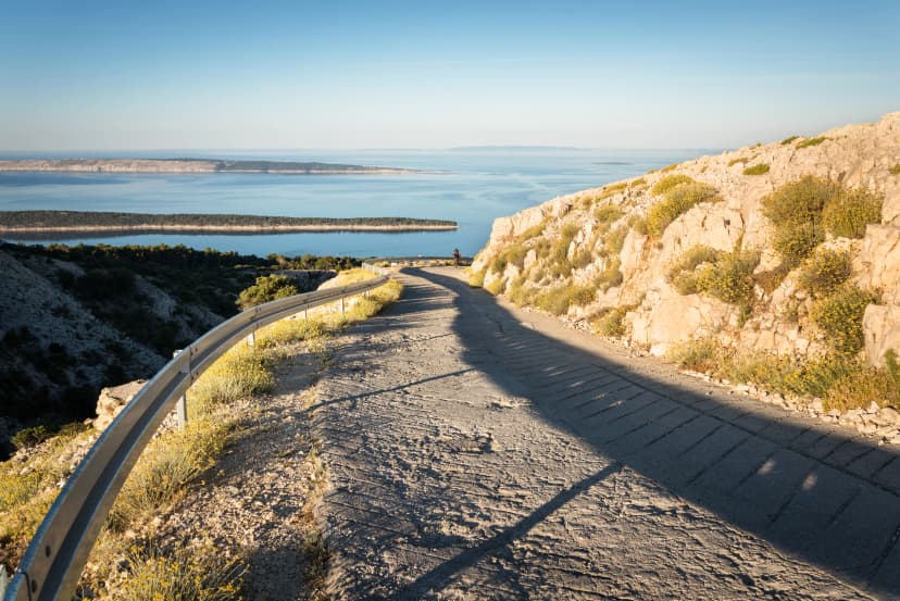Riding a bicycle up a hill called Kamenjak on island of Rab