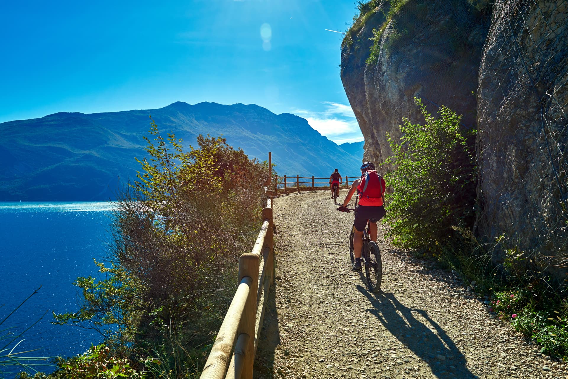 Bicyclists riding a bicycle on the ponale street in Riva del Garda