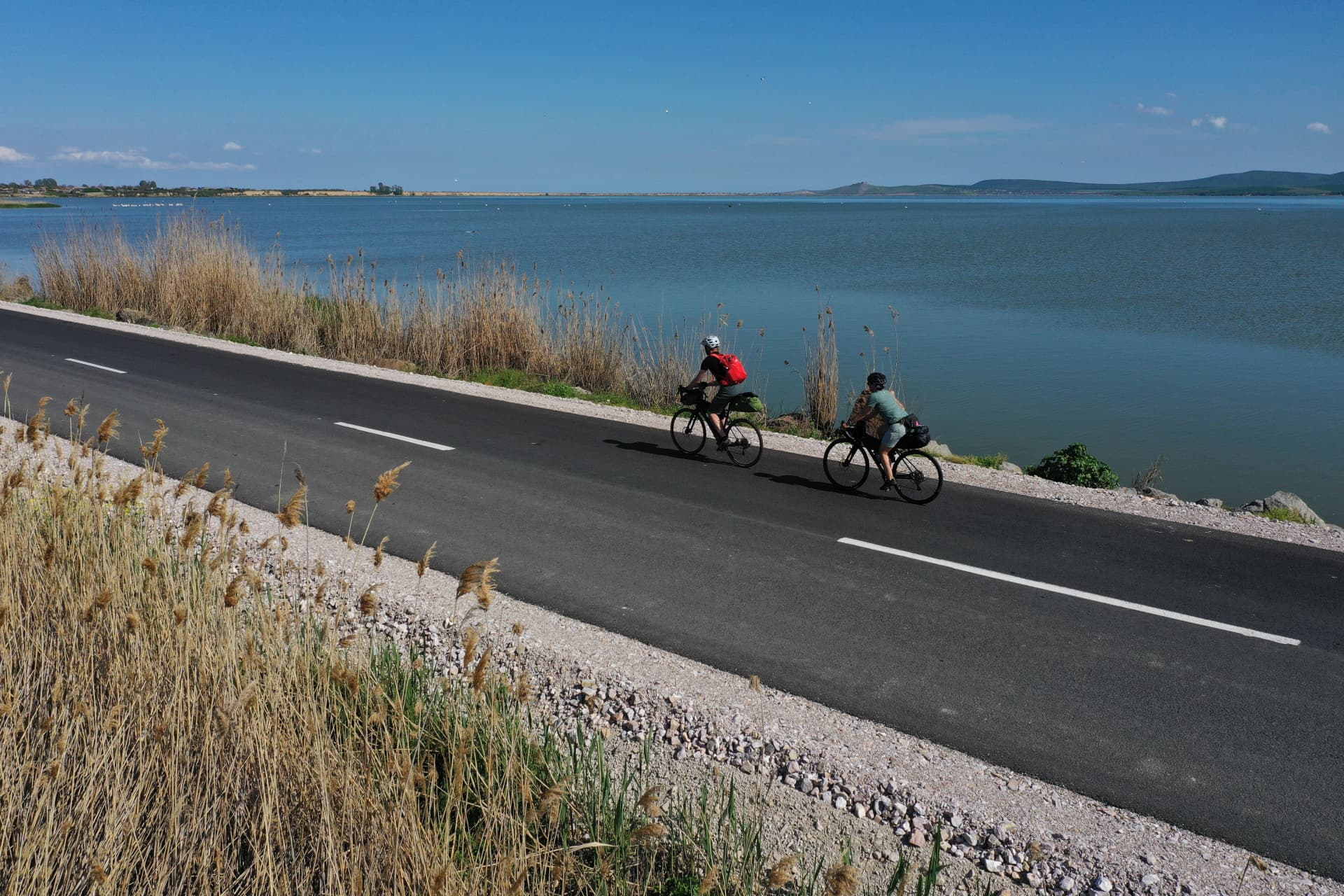Cyclists on a beautiful road aside Razim lake in Dobrogea, Romania