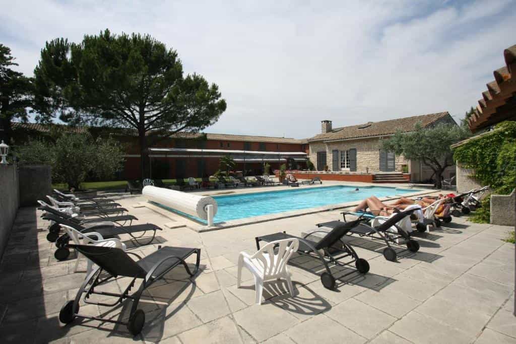 Swimming pool with lounge chairs and stone patio at a villa in France.