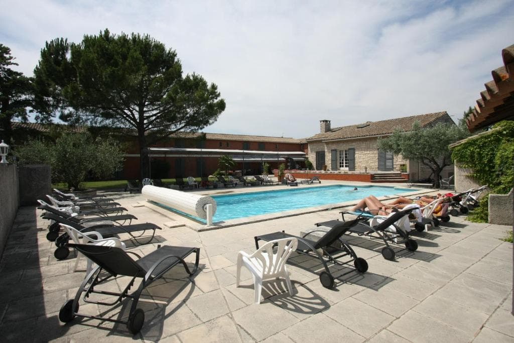 Swimming pool with lounge chairs and stone patio at a villa in France.