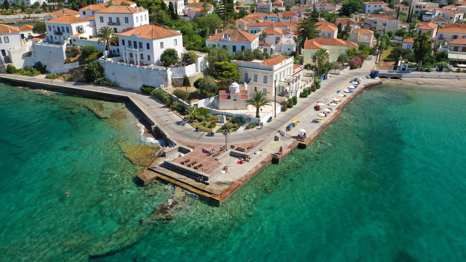 Aerial drone bird's eye view photo of picturesque neoclassic houses in historic and traditional island of Spetses with emerald clear waters, Saronic Gulf, Greece