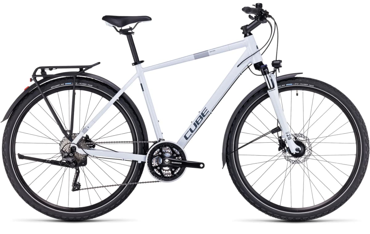 White Cube touring bicycle with rear rack, mudguards, and front suspension fork on a plain background.